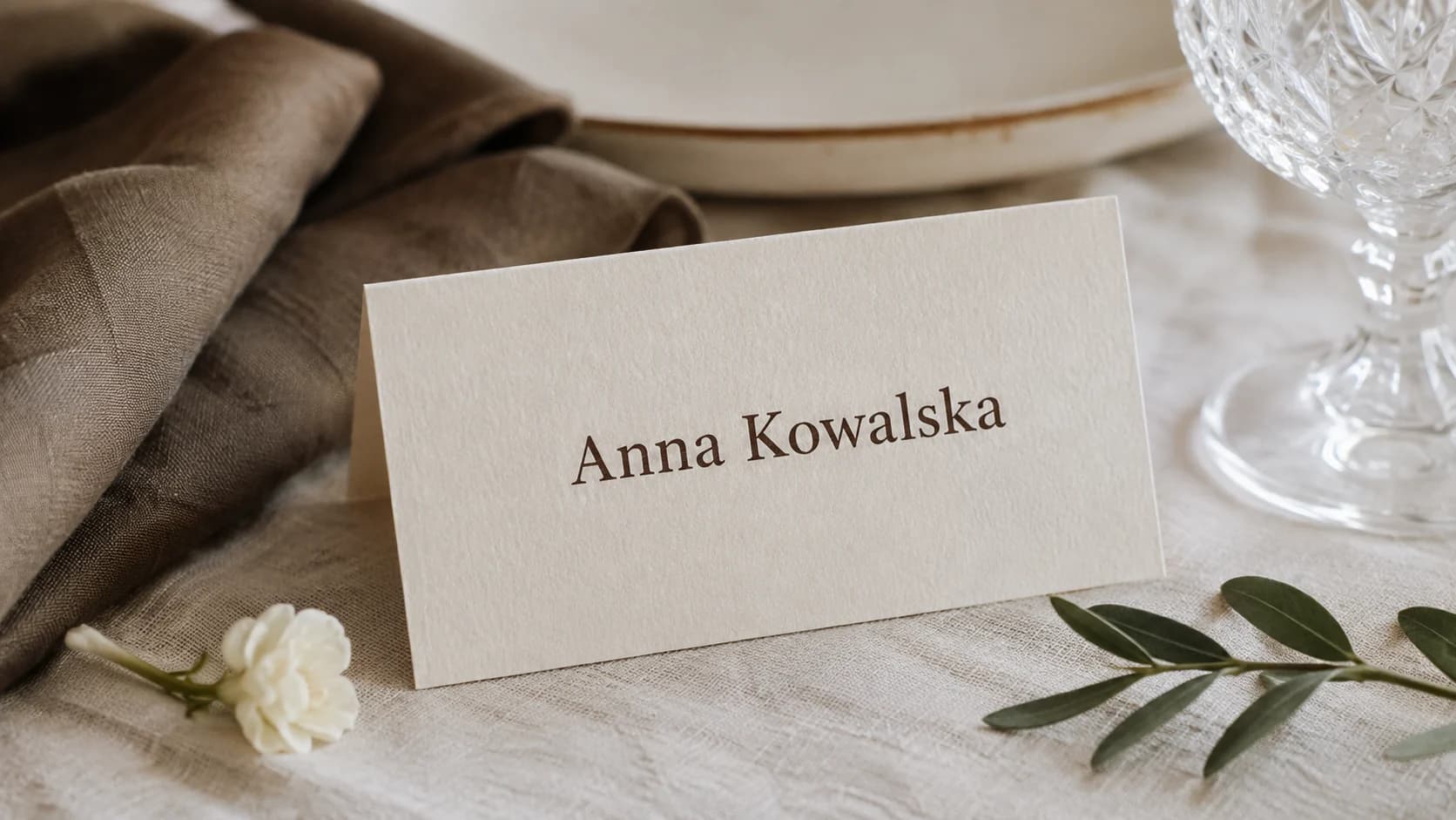 Kremowa winietka z imieniem Anna Kowalska przy eleganckim nakryciu stołu